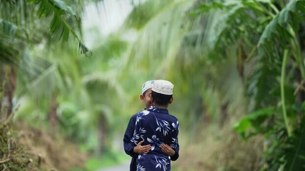 View of two boys hugging in a tropical setting Bangladesh. View of two boys hugging in a tropical setting Bangladesh.