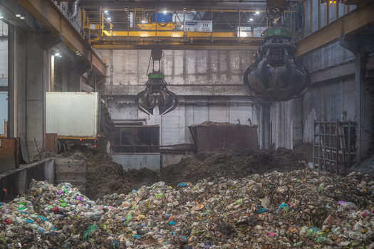 View of the Forsu Iren waste treatment plant with mechanical claws moving organic waste and a truck unloading garbage in Reggio nell Emilia Emilia Romagna Italy. View of the Forsu Iren waste treatment plant with mechanical claws moving organic waste and a truck unloading garbage in Reggio nell Emilia Emilia Romagna Italy.