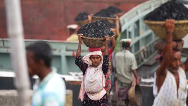 View of workers carrying coal baskets at Aminbazar Bangladesh.
