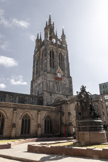 View of the historic Newcastle Cathedral with its prominent Gothic tower and clock face set against a clear blue sky in Newcastle upon Tyne England United Kingdom. View of the historic Newcastle Cathedral with its prominent Gothic tower and clock face set against a clear blue sky in Newcastle upon Tyne England United Kingdom.
