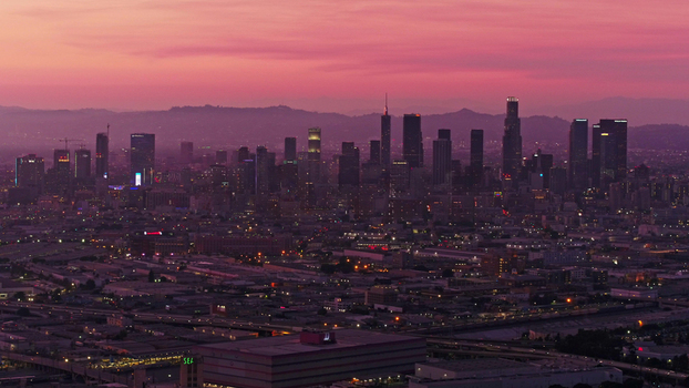 Aerial view of the Los Angeles skyline at sunset with pink sky and illuminated skyscrapers in Los Angeles California United States.