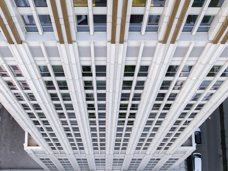 Aerial view of a modern skyscraper facade with geometric window patterns and vertical architectural lines in Poland. Aerial view of a modern skyscraper facade with geometric window patterns and vertical architectural lines in Poland.