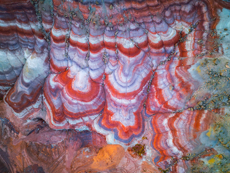 Aerial view of the vibrant multi colored bentonite hills with distinct red white and purple sedimentary layers and eroded terrain in Hanksville Utah United States.