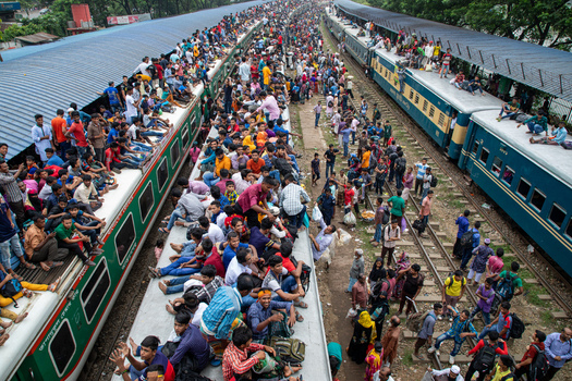 Dhaka Bangladesh 15 June 2018 View of Airport Railway Station crowded with passengers sitting on train roofs and standing on platforms during Eid al Fitr commute. Dhaka Bangladesh 15 June 2018 View of Airport Railway Station crowded with passengers sitting on train roofs and standing on platforms during Eid al Fitr commute.