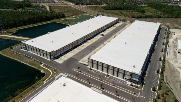 Aerial view of large modern industrial warehouses with white roofs parking lots and retention ponds in World Golf Village Florida United States. Aerial view of large modern industrial warehouses with white roofs parking lots and retention ponds in World Golf Village Florida United States.