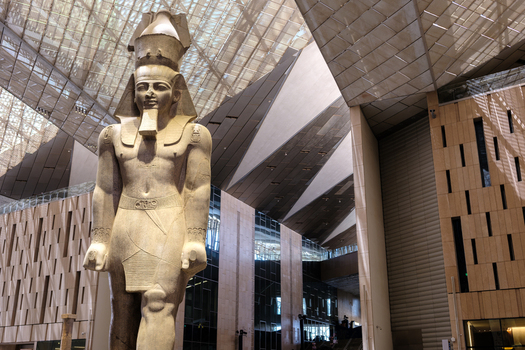 Giza Egypt 16 May 2026 View of the colossal statue of Ramses II standing in the grand atrium of the Grand Egyptian Museum with modern geometric architecture and glass ceiling.