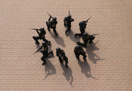 Dhaka Bangladesh 06 January 2017 View of RAB officers in black uniforms kneeling in a circular formation and aiming rifles on a patterned floor during a drill at the RAB Headquarters. Dhaka Bangladesh 06 January 2017 View of RAB officers in black uniforms kneeling in a circular formation and aiming rifles on a patterned floor during a drill at the RAB Headquarters.