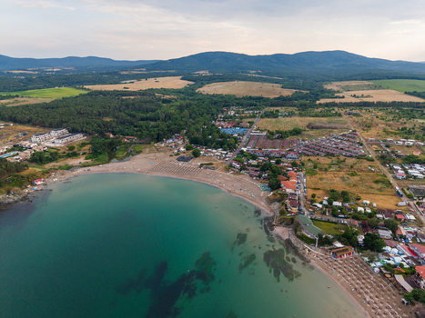 Aerial view of Arapya beach with turquoise waters rows of beach umbrellas surrounding forest and coastal resorts in Burgas Bulgaria. Aerial view of Arapya beach with turquoise waters rows of beach umbrellas surrounding forest and coastal resorts in Burgas Bulgaria.