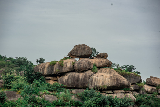 View of large granite rock formations with patches of green vegetation under an overcast sky in the Jos Plateau region Jos North Plateau Nigeria. View of large granite rock formations with patches of green vegetation under an overcast sky in the Jos Plateau region Jos North Plateau Nigeria.