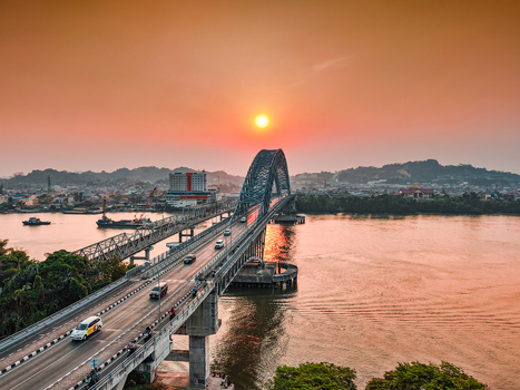 Aerial view of Jembatan Mahakam I over the Mahakam River at sunset with traffic on the bridge and golden light on the water in Kecamatan Samarinda Seberang Kalimantan Timur Indonesia. Aerial view of Jembatan Mahakam I over the Mahakam River at sunset with traffic on the bridge and golden light on the water in Kecamatan Samarinda Seberang Kalimantan Timur Indonesia.