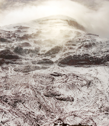 Aerial view of the snow covered slopes and rocky terrain of Volcano Chimborazo under a cloudy sky in Guano Chimborazo Ecuador. Aerial view of the snow covered slopes and rocky terrain of Volcano Chimborazo under a cloudy sky in Guano Chimborazo Ecuador.