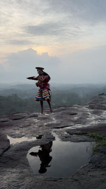 View of a traditional dancer performing on a rocky hill in Kochi India. View of a traditional dancer performing on a rocky hill in Kochi India.