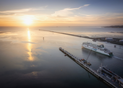 Aerial view of Dublin Port at sunset with a ferry ship navigating the calm waters near the pier in Dublin County Dublin Ireland.