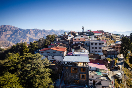 Aerial view of the hill station of Chakrata featuring colorful rooftops and dense green forests against the backdrop of the Himalayan mountain range Chakrata Uttarakhand India. Aerial view of the hill station of Chakrata featuring colorful rooftops and dense green forests against the backdrop of the Himalayan mountain range Chakrata Uttarakhand India.