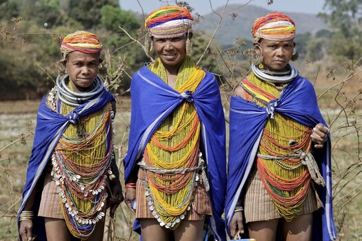 Odisha India 26 March 2026 View of three tribal women standing proudly in their traditional attire vibrant colors contrasting with the arid landscape. Odisha India 26 March 2026 View of three tribal women standing proudly in their traditional attire vibrant colors contrasting with the arid landscape.