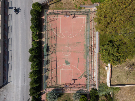 Aerial view of a fenced basketball court surrounded by trees and a road in Istanbul Istanbul Turkiye. Aerial view of a fenced basketball court surrounded by trees and a road in Istanbul Istanbul Turkiye.