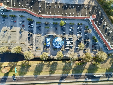 Aerial view of a blue and white striped circus tent pitched near a busy highway and a vast parking lot surrounded by buildings St. Augustine Florida United States. Aerial view of a blue and white striped circus tent pitched near a busy highway and a vast parking lot surrounded by buildings St. Augustine Florida United States.