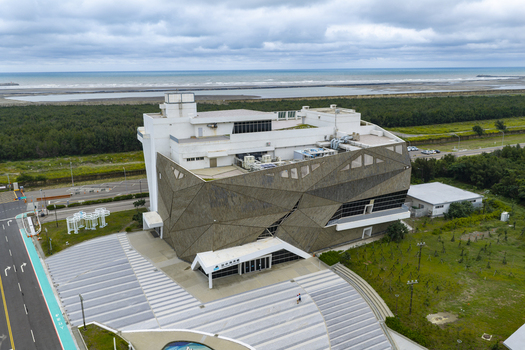 Aerial view of the modern geometric building at Taichung Port with a paved plaza and coastal backdrop Taichung Taichung City Taiwan. Aerial view of the modern geometric building at Taichung Port with a paved plaza and coastal backdrop Taichung Taichung City Taiwan.