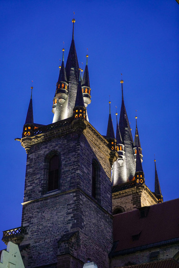 Prague Czechia 03 November 2021 View of the Church of Our Lady before Tyn with its iconic gothic spires illuminated against the deep blue twilight sky. Prague Czechia 03 November 2021 View of the Church of Our Lady before Tyn with its iconic gothic spires illuminated against the deep blue twilight sky.