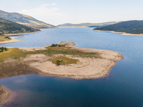 Aerial view of Belmeken Reservoir with its expansive blue water sandy shoreline and surrounding green hills in Pazardzhik Bulgaria. Aerial view of Belmeken Reservoir with its expansive blue water sandy shoreline and surrounding green hills in Pazardzhik Bulgaria.
