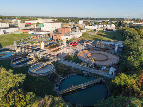 Aerial view of a wastewater treatment plant featuring circular sedimentation tanks and industrial infrastructure in Vilvoorde Flanders Belgium. Aerial view of a wastewater treatment plant featuring circular sedimentation tanks and industrial infrastructure in Vilvoorde Flanders Belgium.