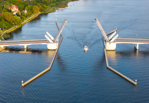 Aerial view of the Sobieszewo drawbridge opening to allow a small boat to pass through the river in Gdansk Pomeranian Voivodeship Poland.