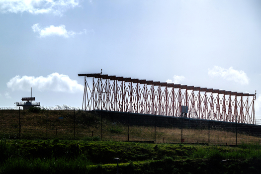 View of the antenna array and radar equipment at Humberto Delgado Airport on a grassy embankment under a bright sky in Lisboa Lisboa Portugal.