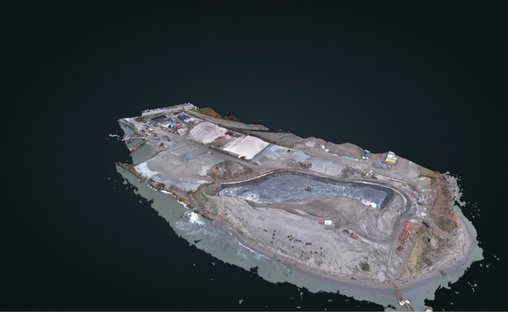 Aerial view of an industrial site on a small island featuring gravel piles excavation areas and heavy machinery in Richmond British Columbia Canada. Aerial view of an industrial site on a small island featuring gravel piles excavation areas and heavy machinery in Richmond British Columbia Canada.
