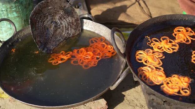 View of jalebi being deep fried in large metal pans Nepal.