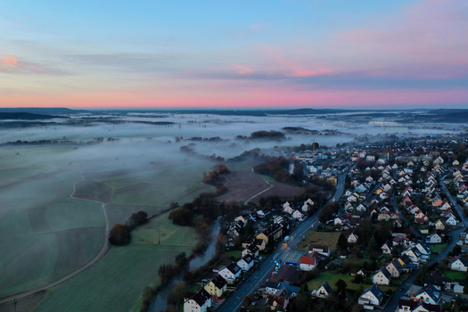 Aerial view of the town of Forchheim nestled in a valley covered by thick morning fog under a pink sunset sky Forchheim Bavaria Germany. Aerial view of the town of Forchheim nestled in a valley covered by thick morning fog under a pink sunset sky Forchheim Bavaria Germany.
