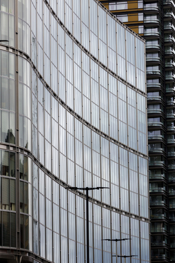 View of a modern glass facade building with a curved design and steel structural elements in London England United Kingdom.