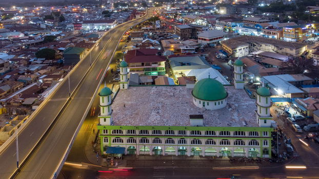 Aerial view of Tamale Central Mosque at dusk featuring its green dome and minarets situated near the elevated highway in Tamale Northern Region Ghana. Aerial view of Tamale Central Mosque at dusk featuring its green dome and minarets situated near the elevated highway in Tamale Northern Region Ghana.