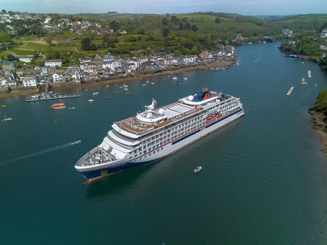 Fowey United Kingdom 01 May 2026 Aerial view of a cruise ship in the Fowey river near Fowey town with small boats and green hills in the background. Fowey United Kingdom 01 May 2026 Aerial view of a cruise ship in the Fowey river near Fowey town with small boats and green hills in the background.