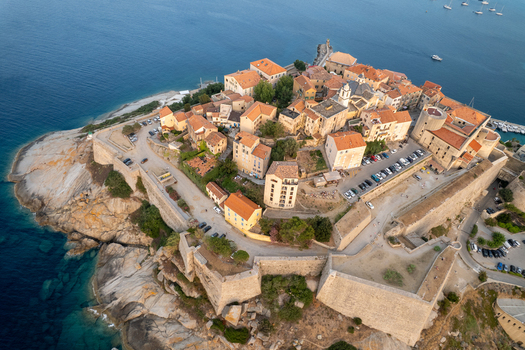 Aerial view of Citadelle de Calvi with its historic stone fortifications terracotta rooftops and narrow streets overlooking the Mediterranean Sea in Calvi Corse France.