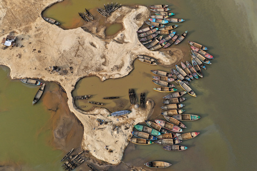 Aerial view of Jadukata River with numerous wooden boats moored along the sandy banks in Sunamganj Sylhet Division Bangladesh. Aerial view of Jadukata River with numerous wooden boats moored along the sandy banks in Sunamganj Sylhet Division Bangladesh.