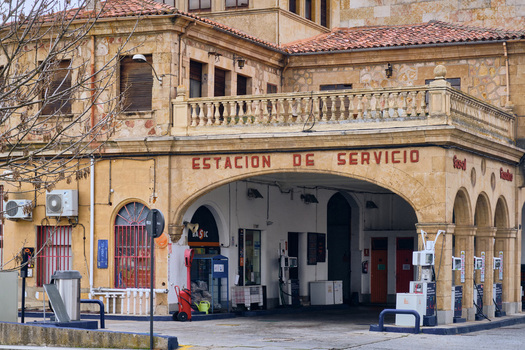 Salamanca Spain 29 November 2025 View of the historic stone facade of a traditional service station with arched architecture tiled roofs and bare tree branches. Salamanca Spain 29 November 2025 View of the historic stone facade of a traditional service station with arched architecture tiled roofs and bare tree branches.