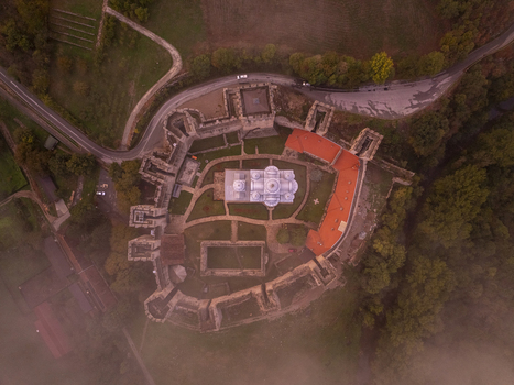Aerial view of Manasija Monastery with its fortified stone walls red tiled roofs and central church surrounded by lush greenery and morning mist in Despotovac Pomoravski okrug Serbia.