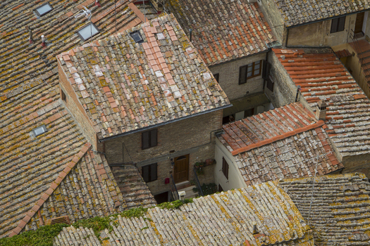 View of terracotta rooftops adorned with moss and lichen create a tapestry of warm hues and textures in the old town San Gimignano Tuscany Italy. View of terracotta rooftops adorned with moss and lichen create a tapestry of warm hues and textures in the old town San Gimignano Tuscany Italy.
