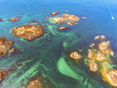 Aerial view of rocky islets and turquoise waters surrounding the Brehat archipelago in Ile de Brehat Brittany France.