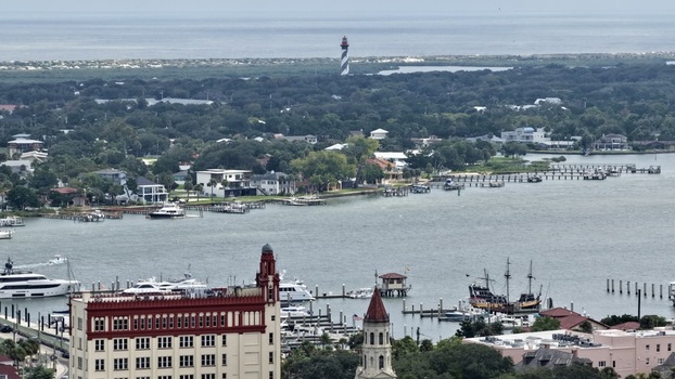 Aerial view of the historic St. Augustine Lighthouse standing tall across the bay with boats docked along the waterfront and coastal architecture in St. Augustine Florida United States. Aerial view of the historic St. Augustine Lighthouse standing tall across the bay with boats docked along the waterfront and coastal architecture in St. Augustine Florida United States.