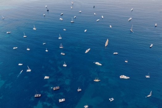 Aerial view of numerous yachts and sailboats anchored in the deep blue Mediterranean Sea off the coast of Cannes Provence Alpes Cote d Azur France. Aerial view of numerous yachts and sailboats anchored in the deep blue Mediterranean Sea off the coast of Cannes Provence Alpes Cote d Azur France.