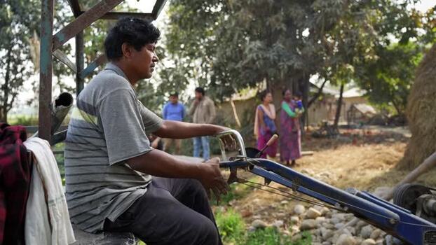 View of a man sitting on a power tiller in a rural village Nepal. View of a man sitting on a power tiller in a rural village Nepal.