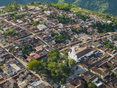 Aerial view of the city s terracotta roofs and the stark white church steeple piercing the sky nestled amidst the lush green hills Salamina Caldas Colombia. Aerial view of the city s terracotta roofs and the stark white church steeple piercing the sky nestled amidst the lush green hills Salamina Caldas Colombia.