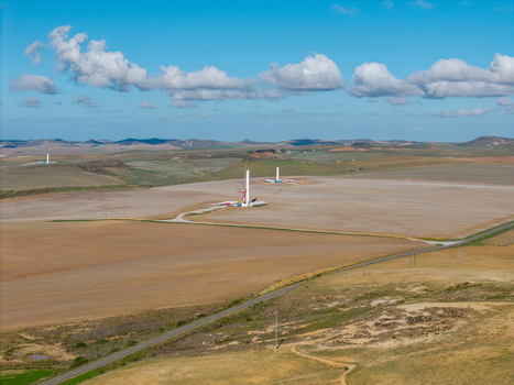 Aerial view of wind turbines under construction in a vast rural landscape with rolling hills and a blue sky with clouds Swellendam Western Cape South Africa. Aerial view of wind turbines under construction in a vast rural landscape with rolling hills and a blue sky with clouds Swellendam Western Cape South Africa.