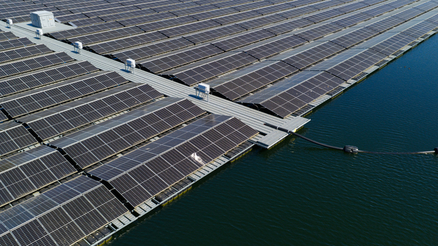 Aerial view of a large floating solar farm with rows of photovoltaic panels on a calm lake under a clear blue sky in Zwolle Overijssel Netherlands. Aerial view of a large floating solar farm with rows of photovoltaic panels on a calm lake under a clear blue sky in Zwolle Overijssel Netherlands.