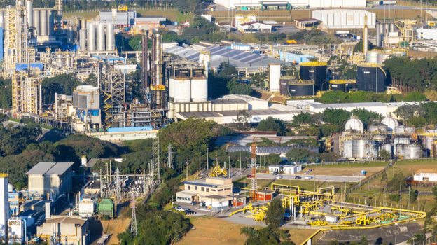 Aerial view of the petrochemical complex featuring industrial towers storage tanks and processing facilities surrounded by lush greenery in Santo Andre State of Sao Paulo Brazil.