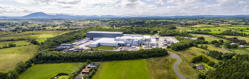 Ballina Ireland 25 September 2026 Aerial view of Coca Cola Ballina Beverages facility surrounded by lush green fields trees and rural landscape under a cloudy sky.