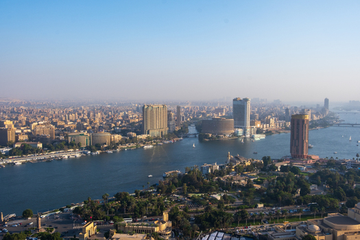 Cairo Egypt 19 October 2025 View of the Nile River snaking through the cityscape its waters reflecting the clear sky flanked by modern buildings and lush green parks. Cairo Egypt 19 October 2025 View of the Nile River snaking through the cityscape its waters reflecting the clear sky flanked by modern buildings and lush green parks.