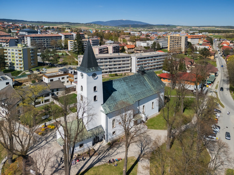 Aerial view of the Roman Catholic Church of Saints Simon and Jude with its white tower and green roof overlooking the town and distant mountains in Namestovo Zilina Region Slovakia. Aerial view of the Roman Catholic Church of Saints Simon and Jude with its white tower and green roof overlooking the town and distant mountains in Namestovo Zilina Region Slovakia.