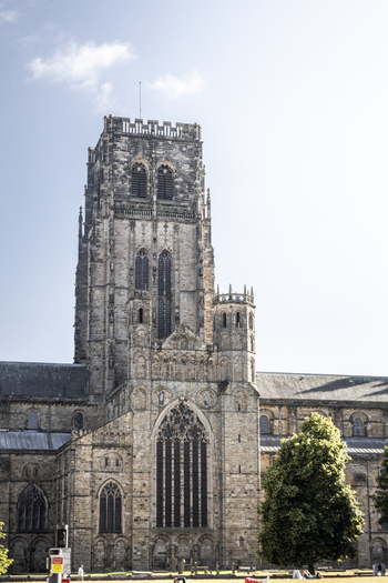 View of the historic Durham Cathedral with its prominent central tower intricate stone masonry and gothic windows under a clear sky in Durham England United Kingdom. View of the historic Durham Cathedral with its prominent central tower intricate stone masonry and gothic windows under a clear sky in Durham England United Kingdom.